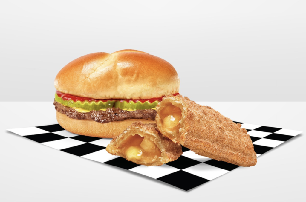 Hamburger with lettuce and tomato beside two breaded fried cheese sticks on a black-and-white checkerboard mat
